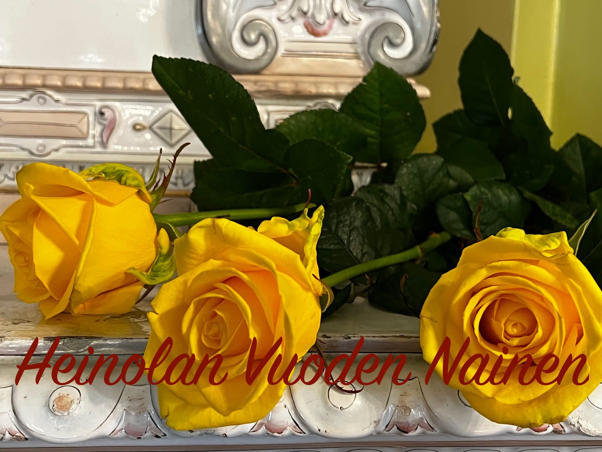 Kolme keltaista ruusua, teksti "Heinolan Vuoden Nainen"
